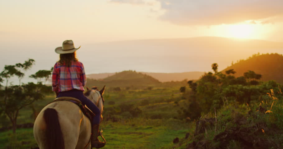 Woman horseback riding at sunset