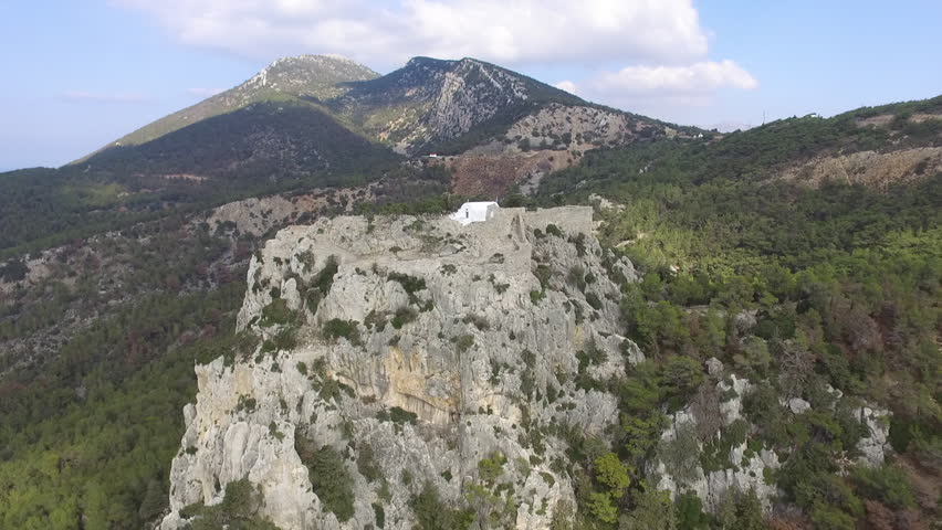 Seacoast and mountain ridge on the beautiful island of Rhodes, Greece near Monolithos with its castle on the rock.