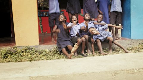 4k of African school pupils/ children smiling and waving for the camera.