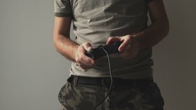 Army soldier playing video game. Man in military camouflage clothes using game controller gamepad