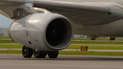Heat shimmer behind jet engine and landing gear of taxiing airplane