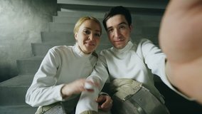 POV of Two young fencers man and woman having online video call using smartphone camera after fencing competition indoors