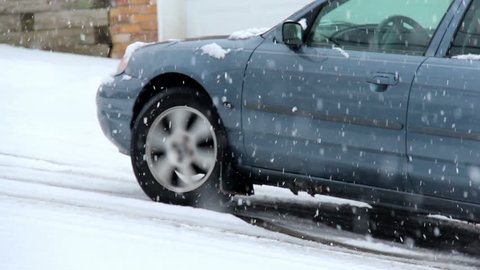 A car struggles to make it up a hill in a Pittsburgh suburb during a snow storm.