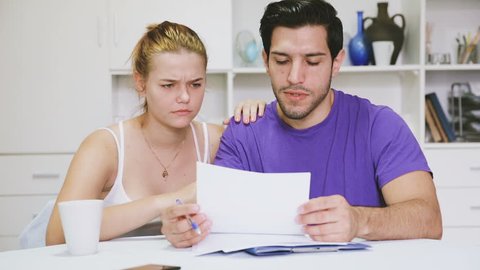 Young couple discussing serious financial situation at home
