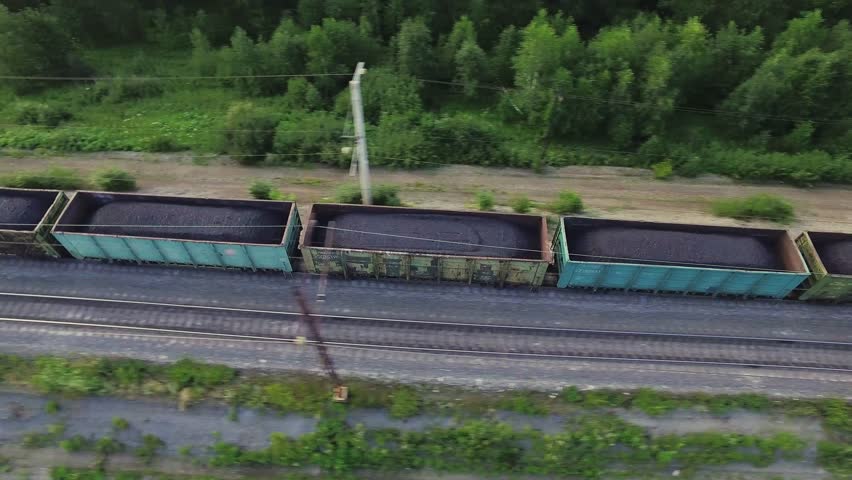 Freight train carries with coal an electric locomotive by two-sided railway in Ural Mountains - Aerial Photography, top view Royalty-Free Stock Footage #33109147