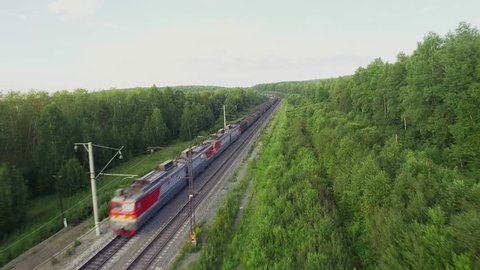 Freight train carries with coal an electric locomotive by two-sided railway in Ural Mountains - Aerial Photography, top view