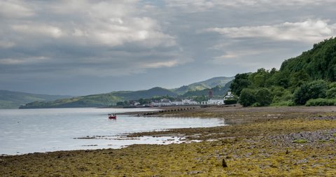 Lonely boat in shore with Inveraray town in background, Highlands, Scotland