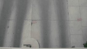 Clip of cars exiting parking garage in afternoon, shot from above looking down.