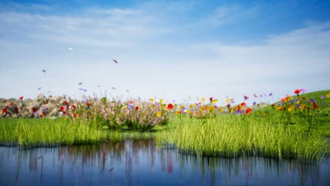 Summer landscape with lake features landscape with a pond reflecting of grass moving from light wind and surrounded by beautiful colorful flowers and flying butterflies