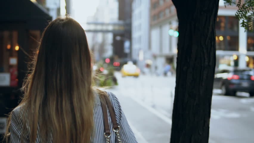 Back view of young brunette woman walking through the street of New York, America. Hair waving on wind. Slow motion. Royalty-Free Stock Footage #33152677
