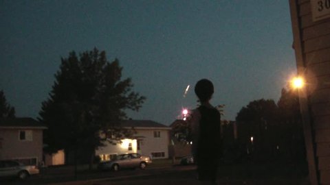 Little boy watching bright fireworks in the nights sky on the 4th of July holiday. : vidéo de stock
