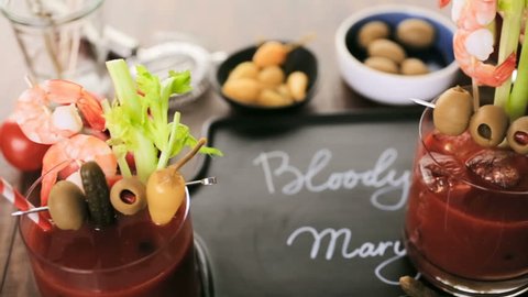 Bloody mary cocktail garnished with olives, pickles, and cocktail shrimp.