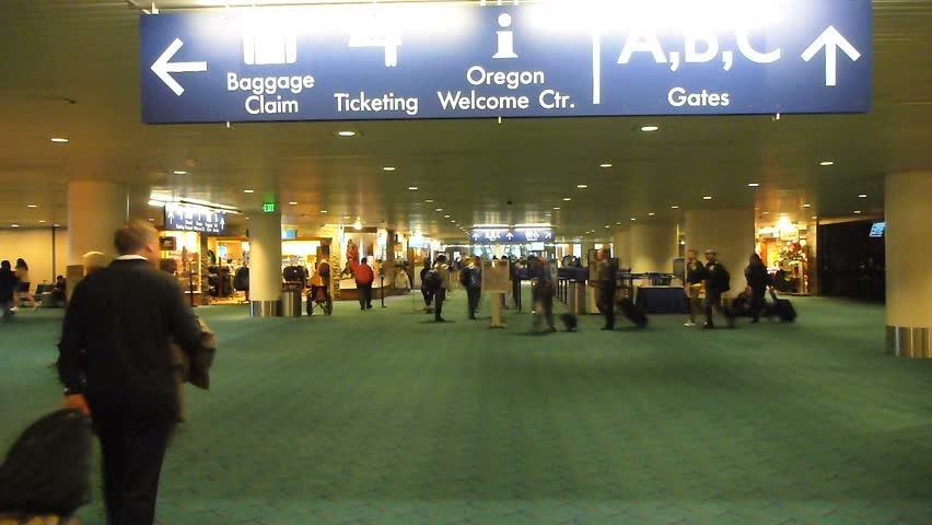 PORTLAND, OREGON AIRPORT - CIRCA 2013: Many people traveling with luggage at