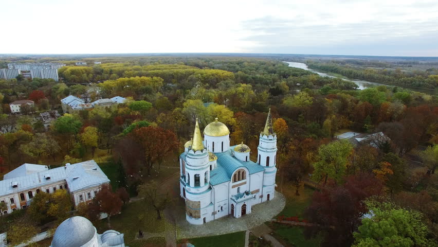 4K .Aerial. Christian church in  autumn city with yellow trees and river