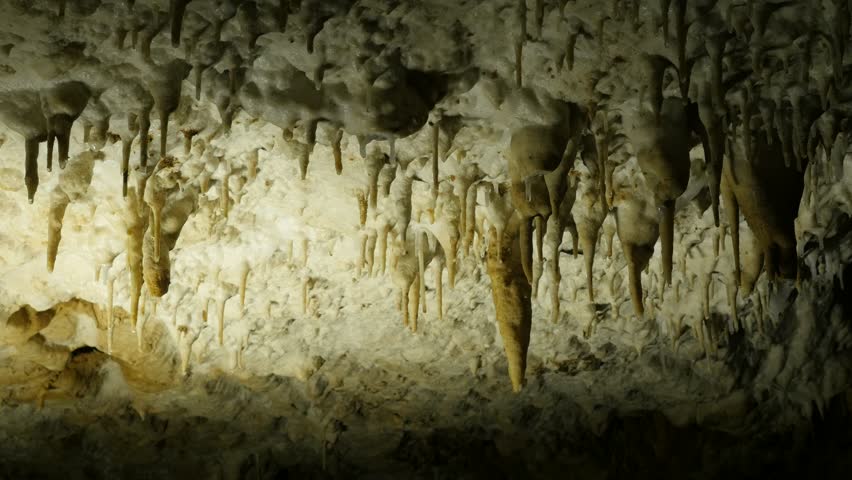 Forming of of stalactites in old cave 3840X2160 UltraHD footage - Drops of water fall from underground  cavern ceiling  2160p 30fps UHD video