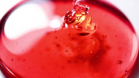 Pouring liquid Red Honey Dripping on White Surface Close Up Macro