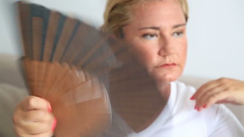 Woman fanning herself in hot summer day