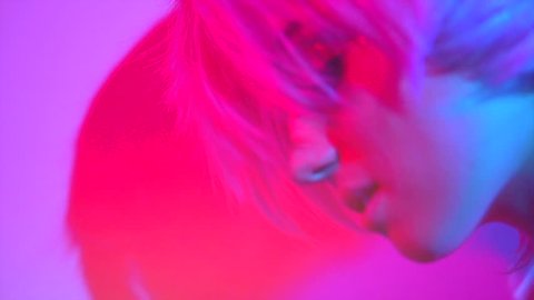 Disco woman dancing on party. Fashion model girl in colorful neon lights, beautiful girl with trendy make-up and haircut. Colorful make up. Over colourful vivid background. 4K UHD slow motion video  庫存影片