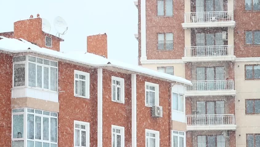 Snow falling in front of the living block of flats. Living flats in winter
