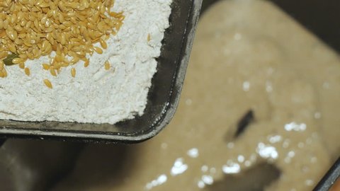 Preparation of the dough for whole rye wheat bread. Flax, pumpkin seeds and whole-wheat flour poured into the form of a bread machine.