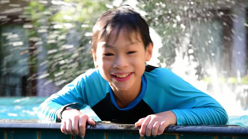 Young Asian boy having fun at pool 