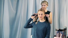 Hairdresser does a hairstyle for a girl