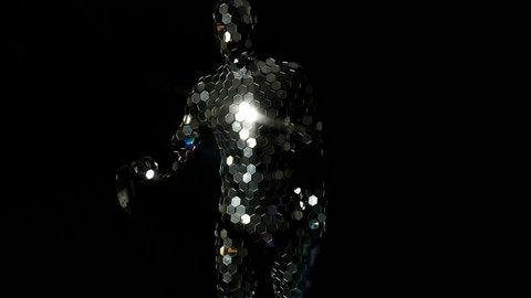 a dancer performs wearing an incredible disco mirror suit that sparkles in the light
