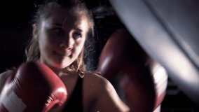 A girl is a boxer. The girl is training in the boxing hall. The girl is beating a punching bag. - Powered by Shutterstock - Get 15% off with code: PIKWIZARD15
