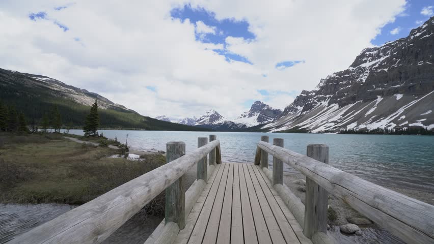 Young couple walking on wooden bridge by the mountain lake in Banff national park in Canada. People love couple travel concept.
4K video resolution, Alberta, Canada