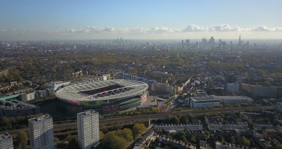 Aerial Drone footage of london looking south over emirates stadium at the london skyline including the shard. A train goes by underneath. Royalty-Free Stock Footage #33208129