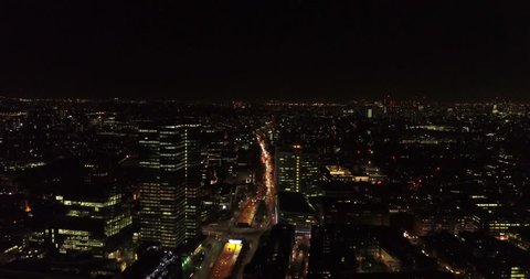 Aerial drone flight above London, uk at night capturing the city lights, landmarks on the Thames and glass office buildings.