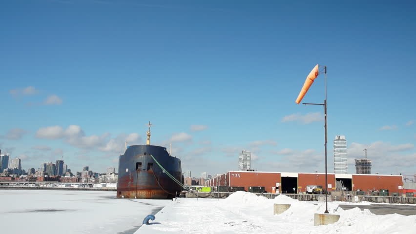 Limp windsock moving slowly in a gentle breeze beside the frozen waters of Lake Ontario. Not graded.