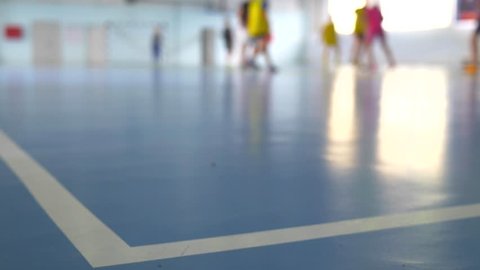 Football futsal training for children. Indoor soccer young player with a soccer ball in a sports hall.