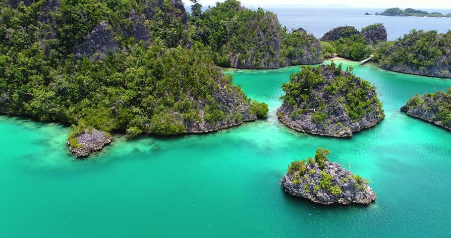 AERIAL: Pianemo Islands, Blue Lagoon with Green Rocks, Raja Ampat, West Papua, Indonesia.  Royalty-Free Stock Footage #33223105