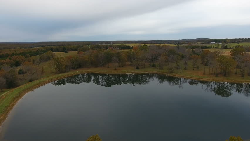 Aerial flight over a lake surrounded by fall trees