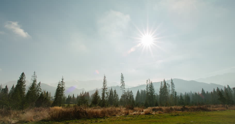 4K Time Lapse of an Amazing Ladscape with Mountains, Forest and Clouds on Sky driven by Wind