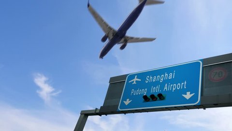 airplane flying over shanghai airport signboard