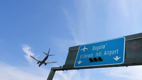 airplane flying over bogota' airport signboard