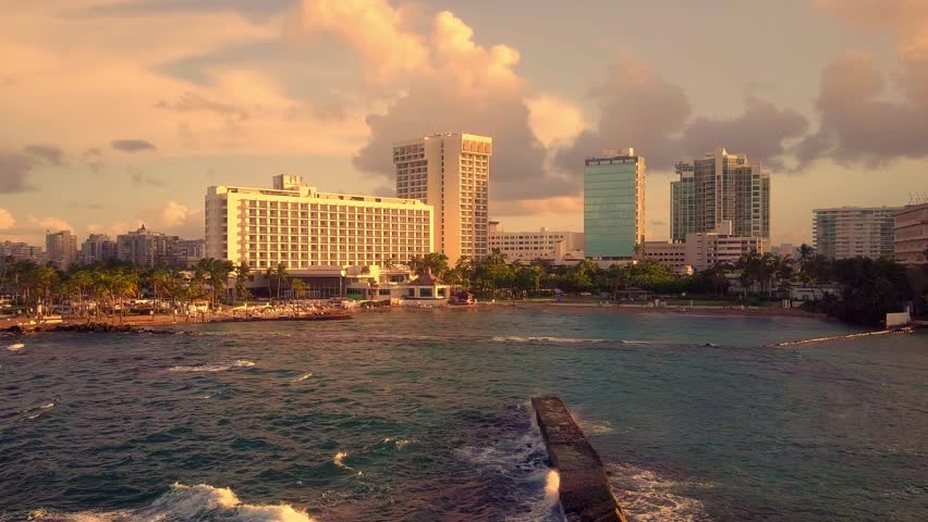 San Juan Puerto Rico at sunset. Unique view from the water as the waves crash against the rocks
