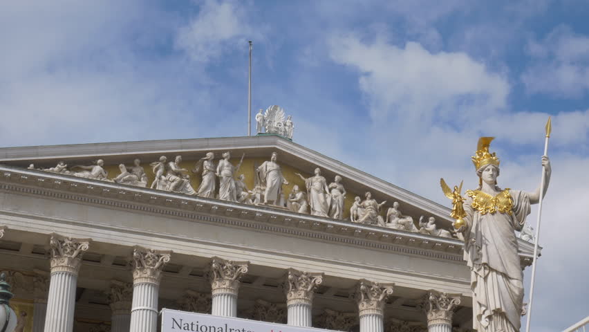 Time lapse style of moving clouds over top of parliament building and Athena Fountain in Vienna, Austria.
