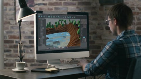 Video Game Designer Works on a New 3D Level on His Personal Computer. He Works as a Developer in a Creative Office Environment. Shot on RED Epic 4K UHD Camera.