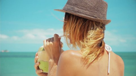 Woman drinking fresh coconut water with straw on beach fun vacation 3 shots