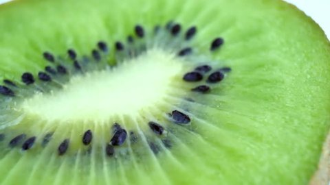 Juicy kiwi rotates as background. Slice of fresh kiwi fruit isolated on white background