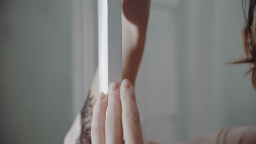 The girl is dressed in a robe and underwear. Beautiful girl in underwear near a white wall.