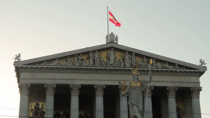 Austrian flag waving shaking in the wind on the parlament government building in the capital city Vienna