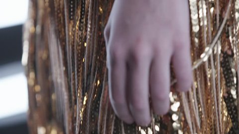 Gold shiny sparkling background. Glowing glittering fashion sequined textile or cloth with stars in slow motion. Details of beautiful golden dress with sequinsの動画素材