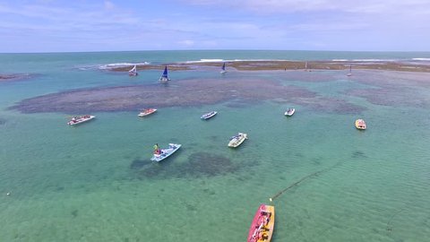 Aerial view over crystal clear waters and coral reef barriers, severals sailing boats in Porto de Galinhas beach - Pernambuco, Brazil