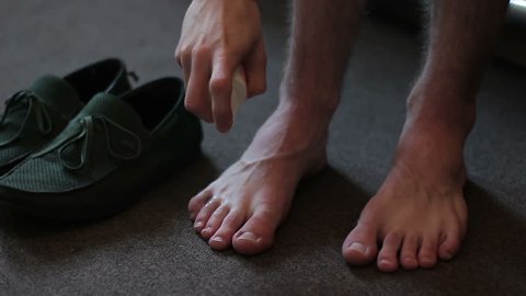 A man applying a remedy for the smell of his feet