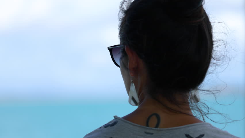 A close up shot of a beautiful female with a back tattoo.