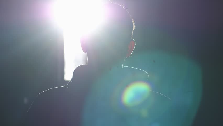Silhouette of man standing by large window looking over the sun with lense flare effects. 3840x2160 | Shutterstock HD Video #33282280